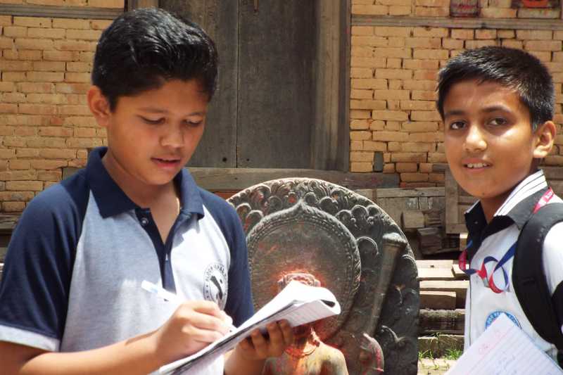 two boys students collecting data in what looks like a cultural hertiage